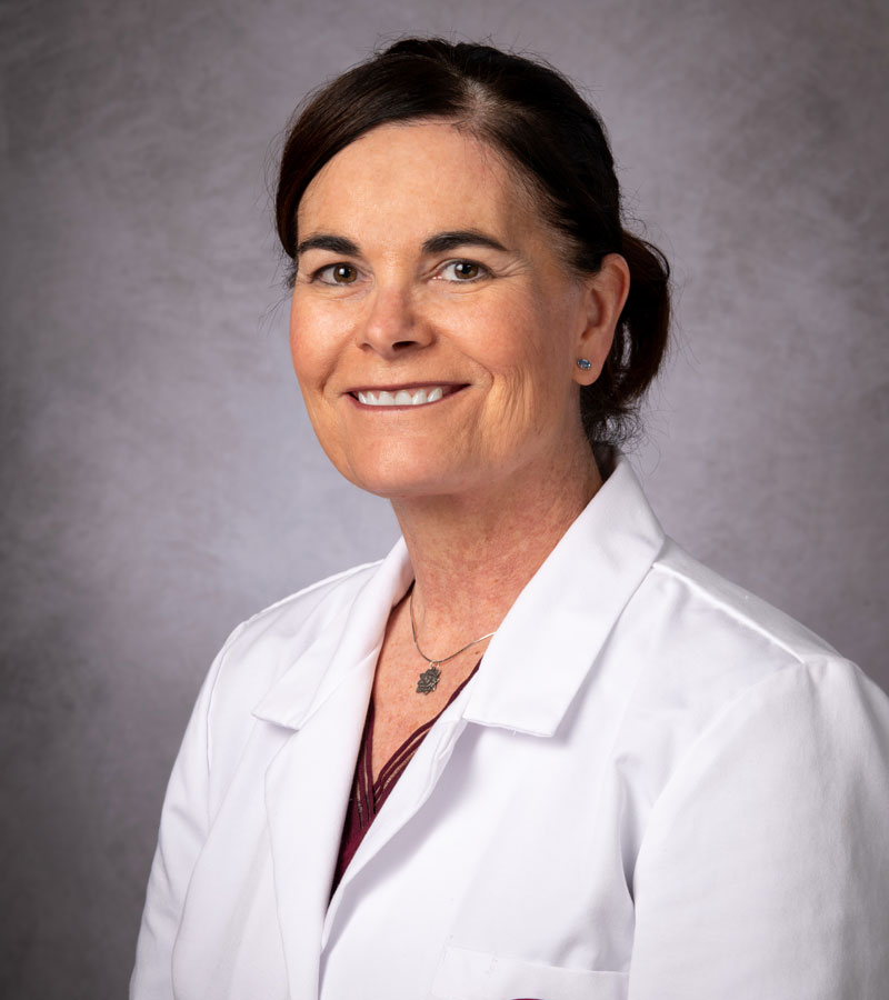 Portrait of Amy Goodin with dark hair wearing a white lab coat.