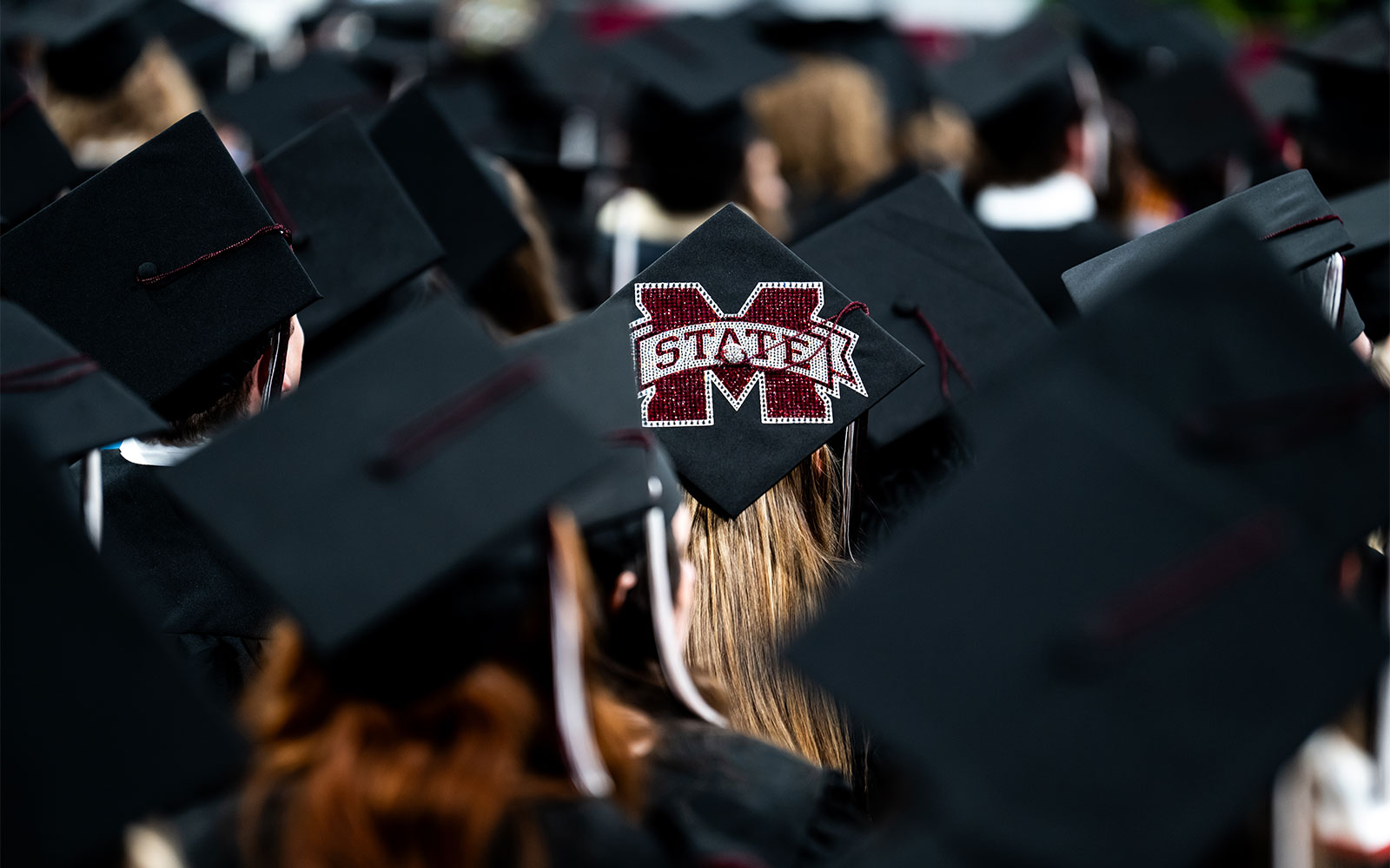 Photo by Grace Cockrell of black graduation caps with one that has an MSU logo 