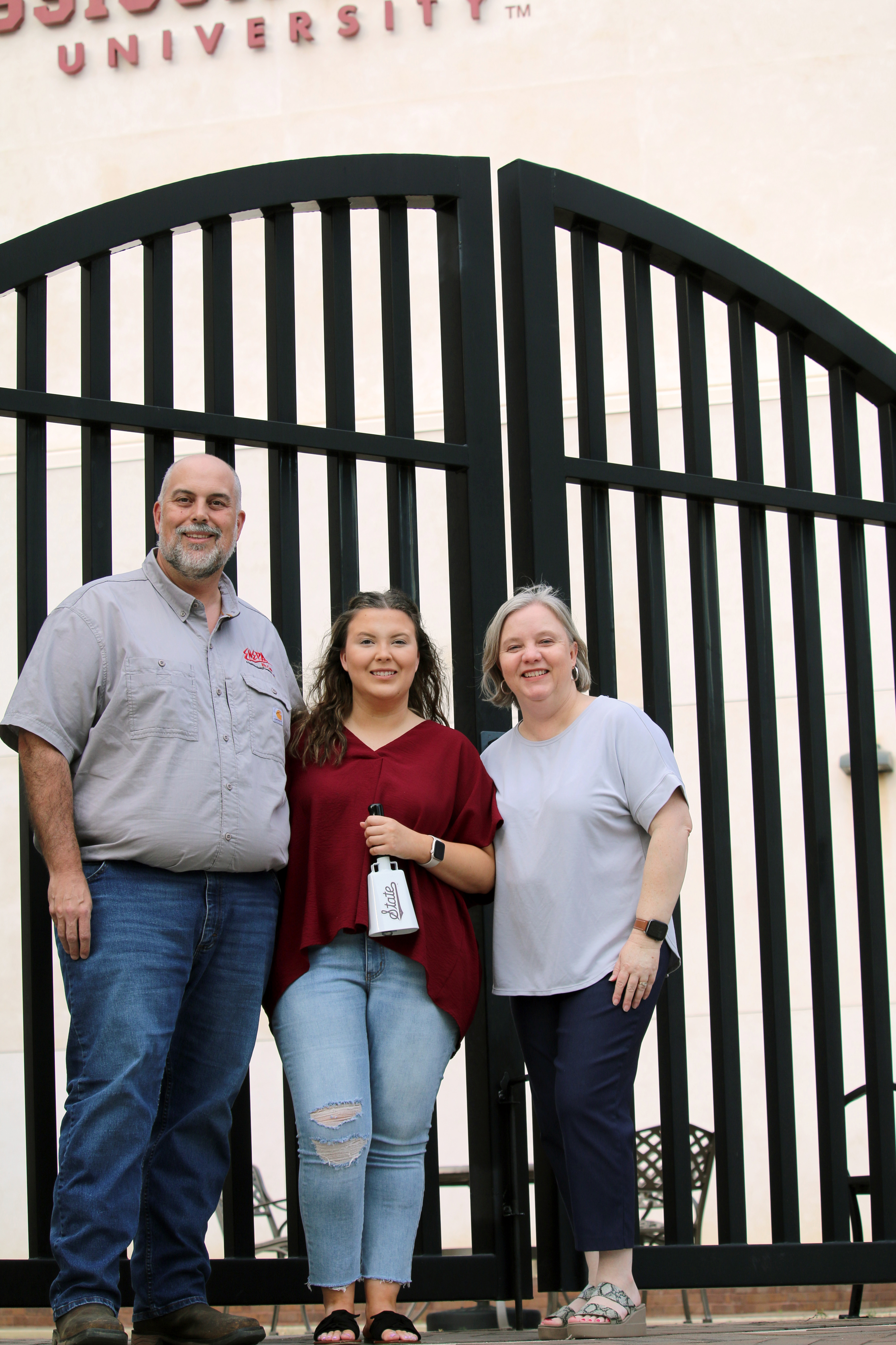 a white male, young woman and middle age woman outside of gates