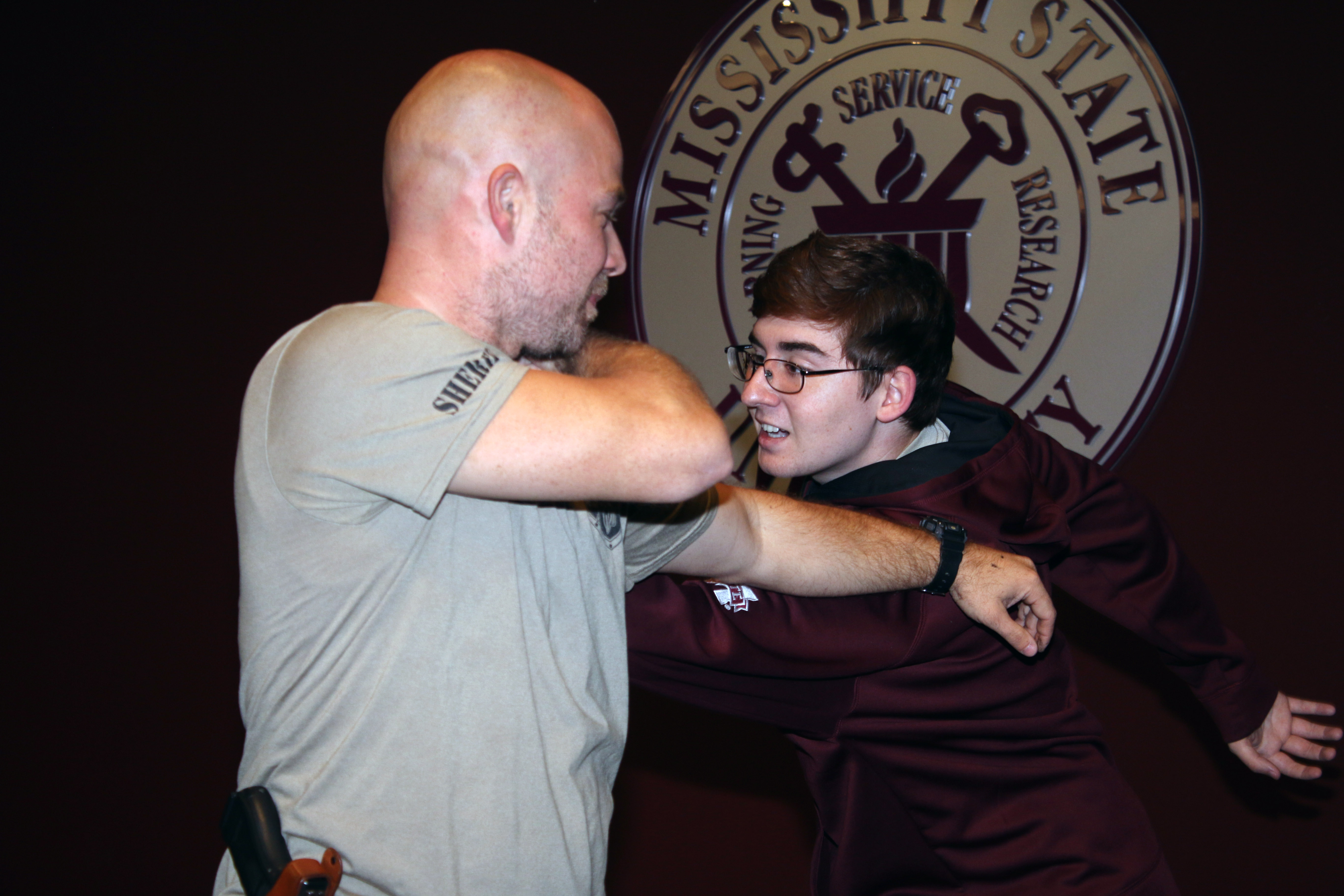 Phillip Hendricks, narcotics commander from Hattiesburg demonstrates self-defense moves with Mason Kiefer, a history major at MSU-Meridian