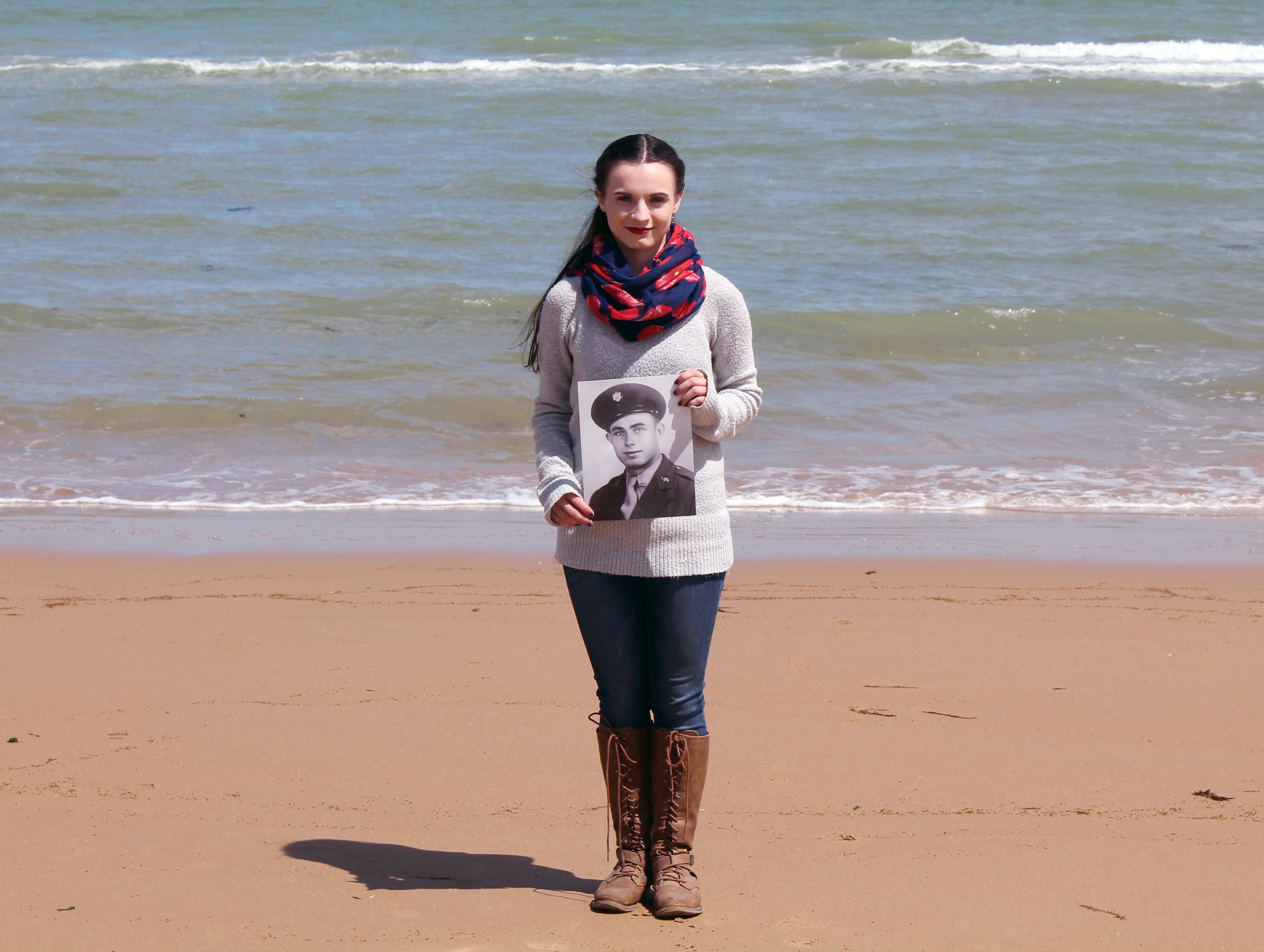 Kayla Jordan, a 19-year-old MSU-Meridian history senior from Sweetwater, Alabama, holds a photo of her great grandfather, Noah Raymond Vick at the Easy Red Sector of Omaha Beach. (Photo submitted)