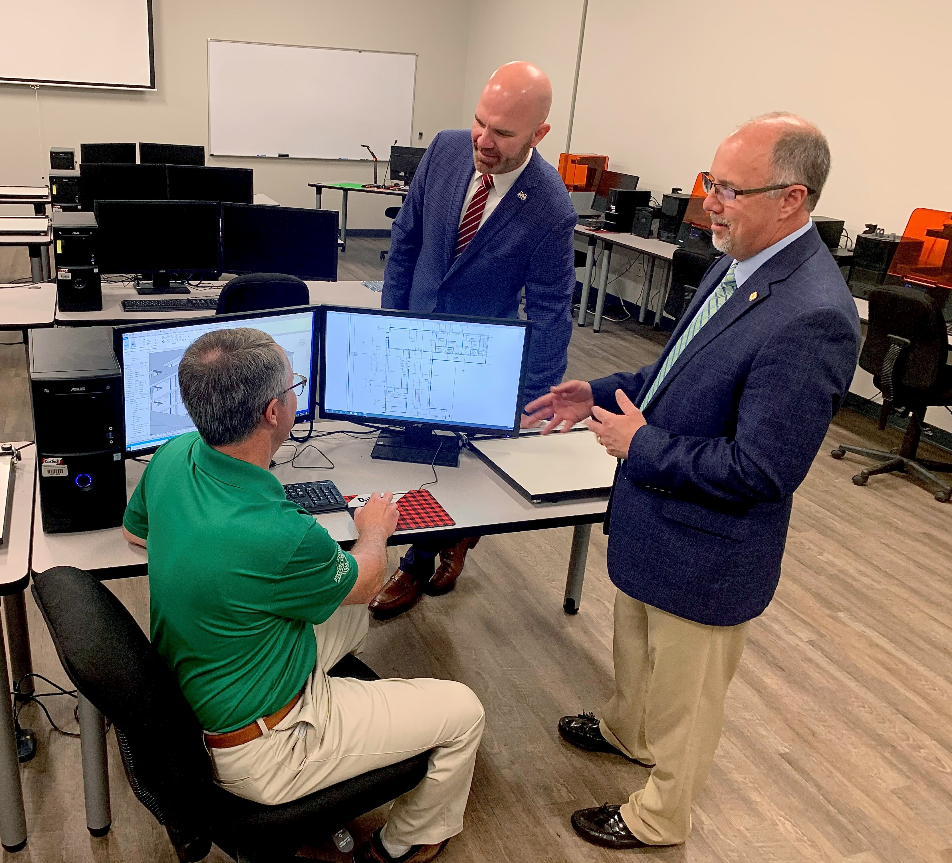Stewart Brown (l), program coordinator and instructor for MCC's 3D CAD Engineering shows MCC president Tom Huebner (right) and Terry Dale Cruse, associate vice president and head of campus at MSU-Meridian some computer software used in h 