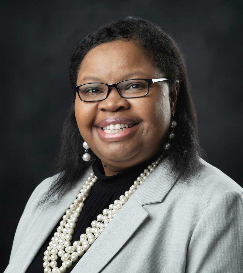 African American woman with glasses in gray suit