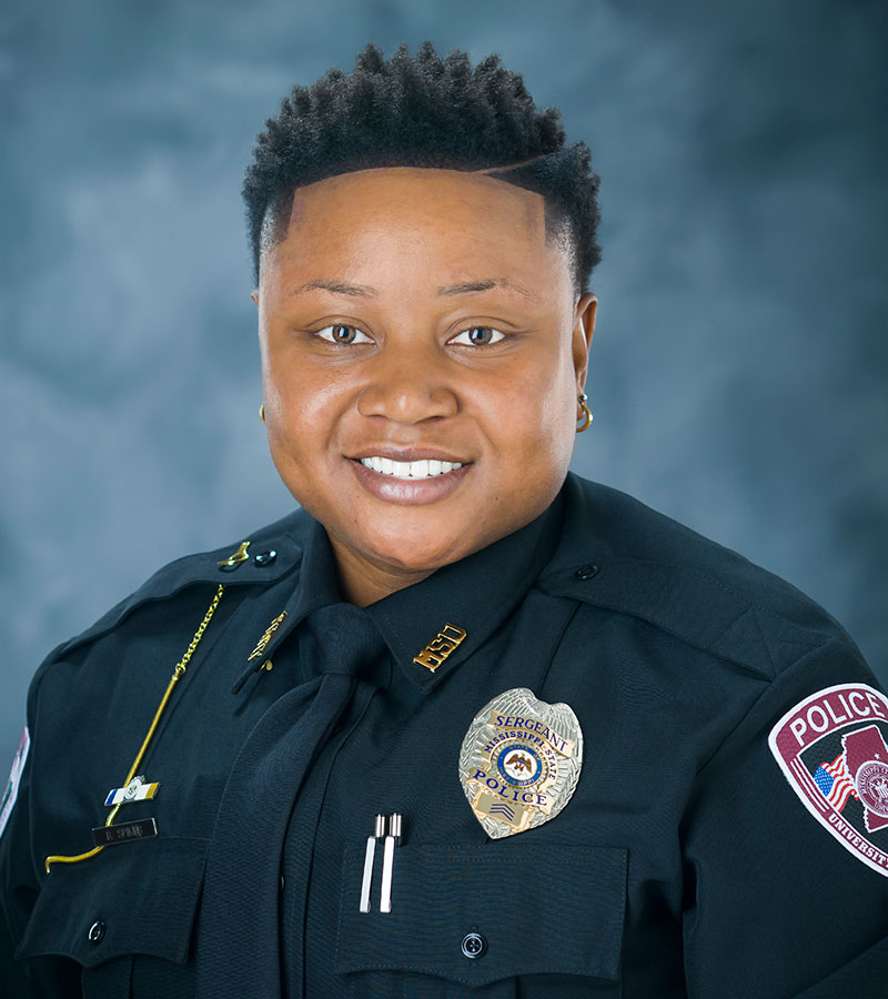Portrait of Sergeant Breonne Spikes wearing a black police uniform with her badge and short dark hair.