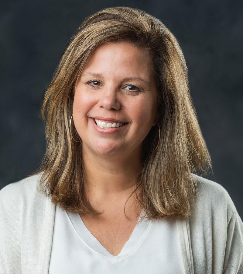 Portrait of Michelle Stubbs with brown shoulder length hair and a light top
