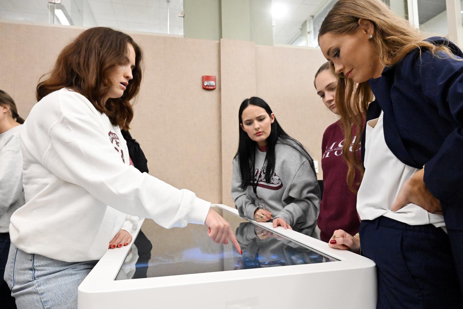 Recently seated Physician Assistant Students (from left to right) Presley Gautier, Ally Berninato, Maybri Eldridge and Brittany Odom check out the state-of-the art Anatomage tables they will be using to train as MSU-Meridian’s newest cohort of Master of Physician Assistant Studies students. (Photo by Marianne Todd/MSU-Meridian)