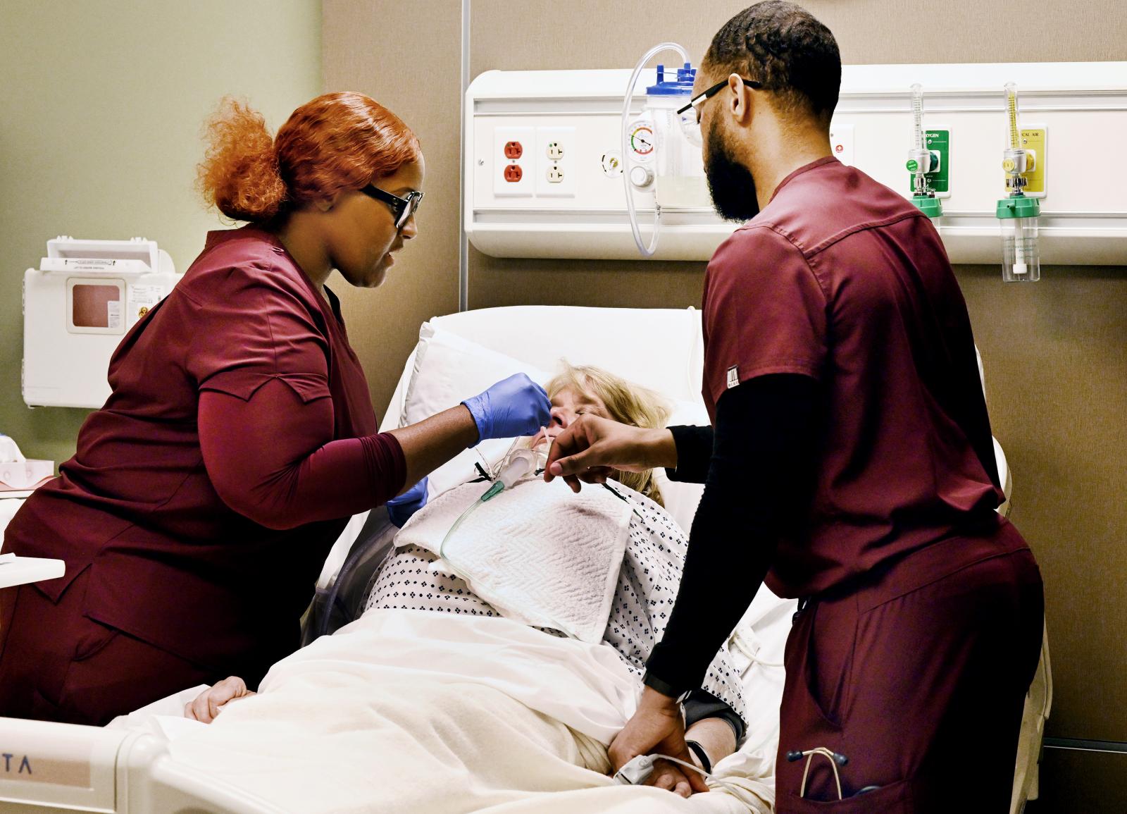 Mississippi State Master of Science in Nursing students Latrina Sherman of Meridian and DeKendrick Rushing of Walnut Grove, work with Standardized Patient Gale Dunaway on a complex tracheostomy care procedure in the MSU Center for Simulation. The center received national accreditation by the Society of Simulation in Healthcare in Teaching/Education and Human Simulation this month. (Photograph by Marianne Todd)