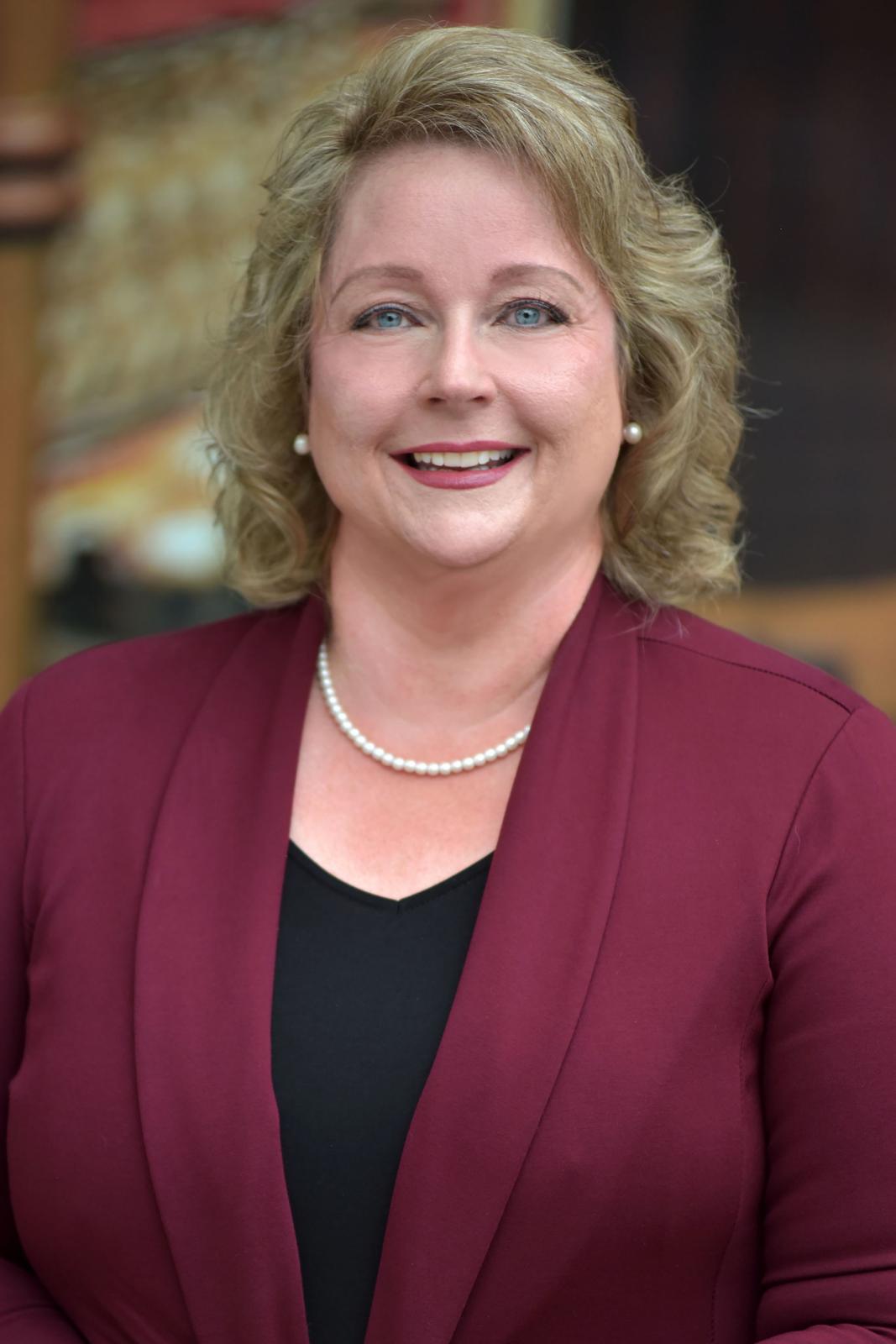 Photo of Katherine Rigdon in maroon jacket smiling at camera