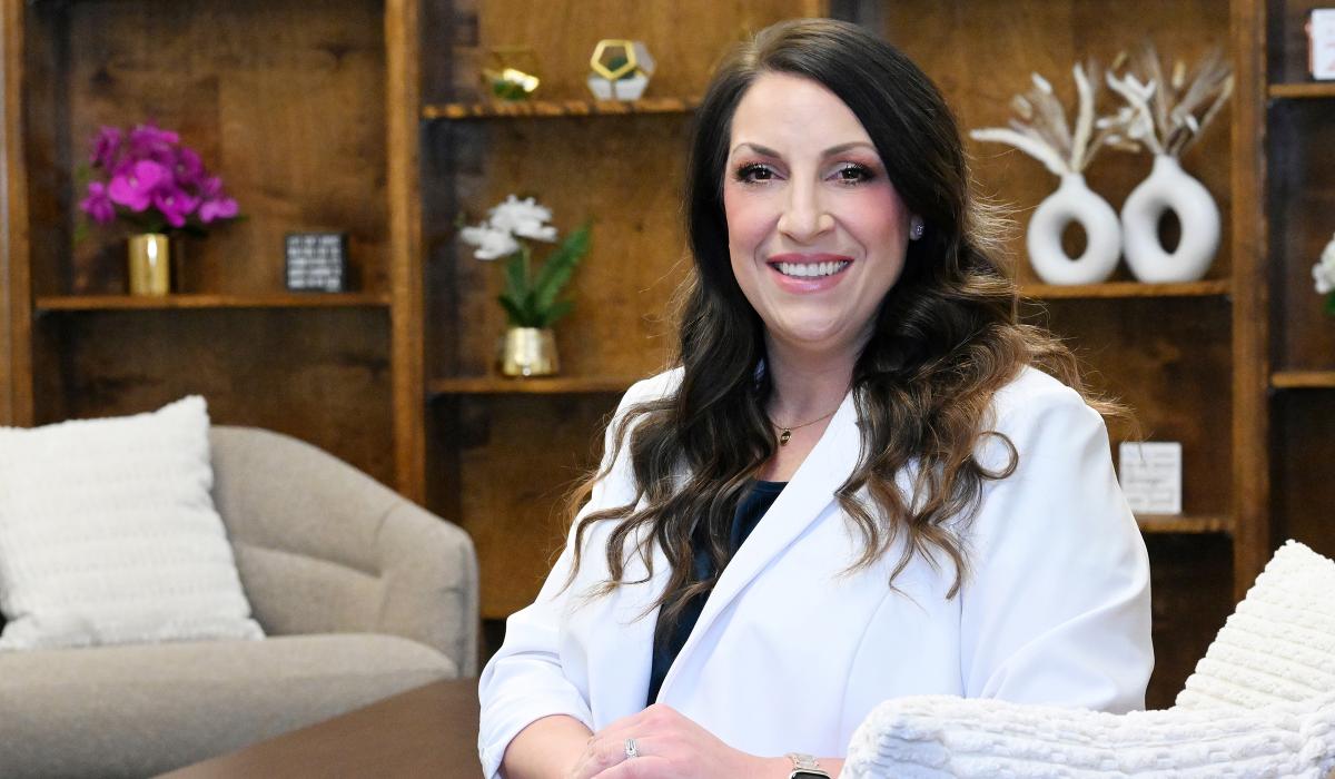 Portrait of Kortney Green with long hair wearing a white coat.