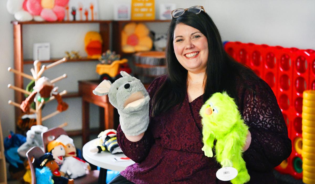 Portrait of Sarah Beth Cooper holding puppets.