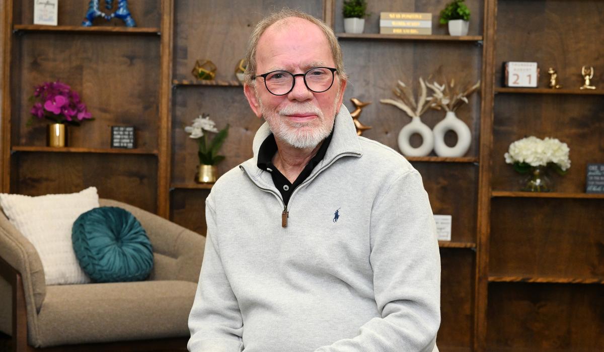Portrait of James Shumate wearing white polo sweater.